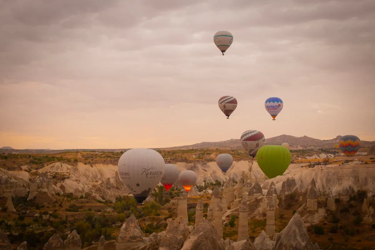 Hot-air balloons floating over a valley at sunrise