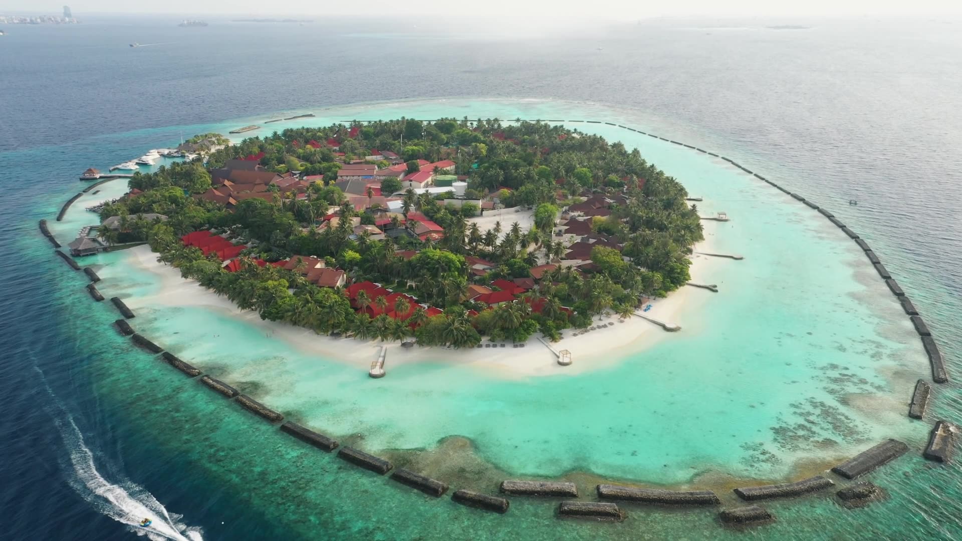 Aerial view of a tropical island resort ringed by turquoise lagoon